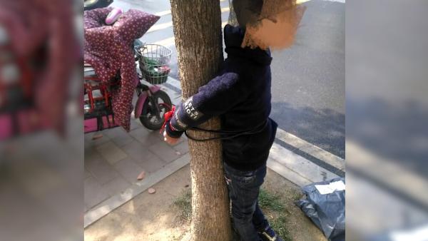 9岁儿子不上学,母亲将其绑校门前树上